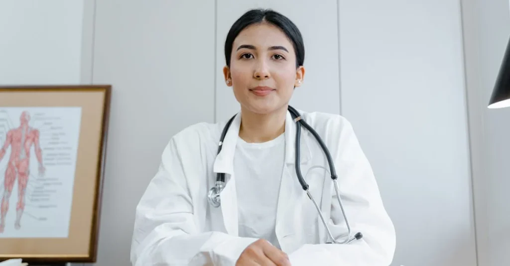 A female nurse health coach confidently sits at her desk, ready for consultation in a medical office.